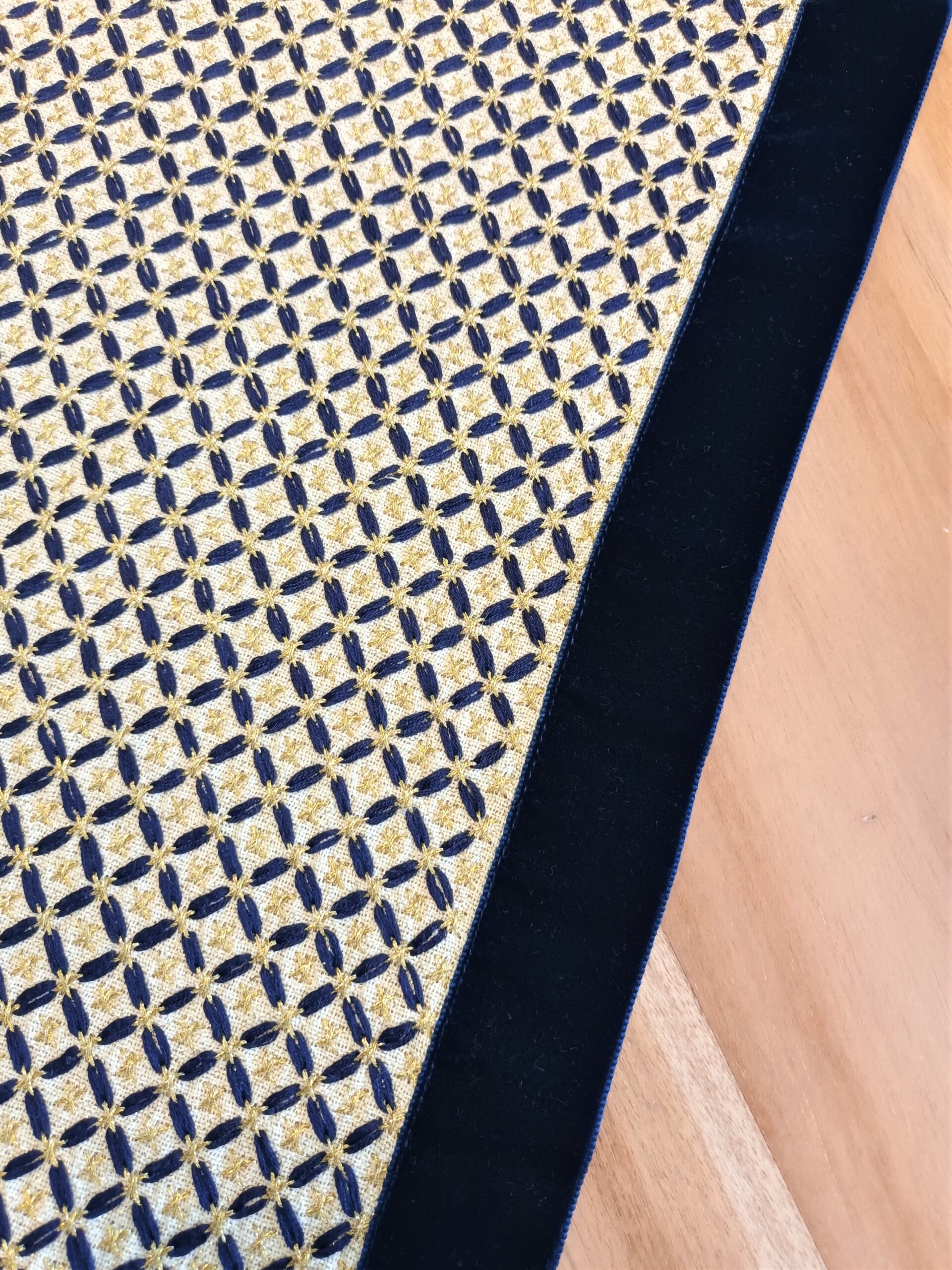 Medium tablecloth with embroidery in dark blue with gold. Blue velvet ribbon all around. Dimensions 0,90 x 0,90cm