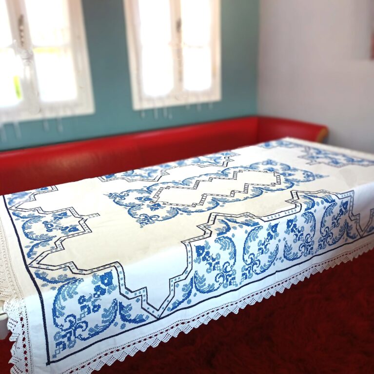 Extra large tablecloth with embroidery in blue with geometrical patterns and white lace with crochet all around. Dimensions 1,30 x 2,00m
