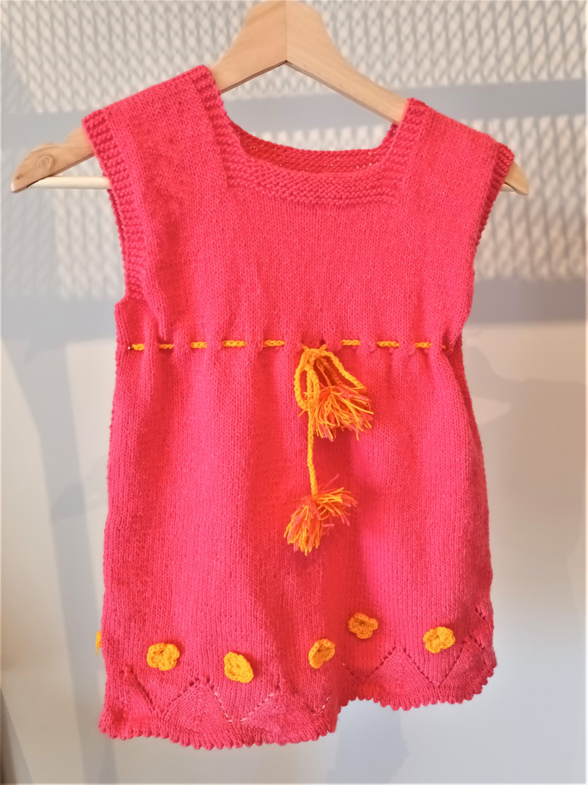 Handmade baby dress with crochet in magenta with orange details